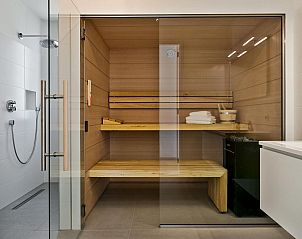 Stijlvolle slaapkamer met groot raam in Waterlijn 10, bungalow in Kamperland, Zeeland.