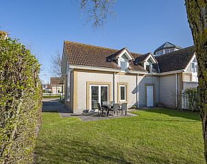 Villa 5B in Kamperland, Noord-Beveland, Zeeland biedt een zonnig terras en groene tuin voor een ontspannen vakantiehuiservaring.
