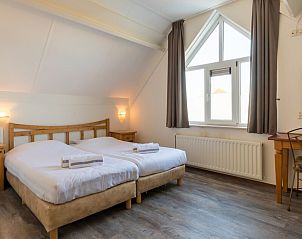 Moderne badkamer in Villa 5B, een vakantiehuis in Kamperland, Noord-Beveland, met ligbad en strak design voor ultiem comfort.