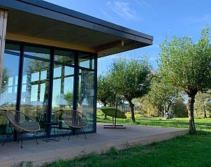 Terrace of vacation home in Kamperland with comfortable chairs and views of green surroundings in North Beveland, Zeeland.
