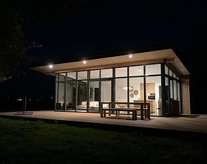 Vacation home in Kamperland lit in the evening, offers a warm atmosphere in North Beveland, Zeeland.