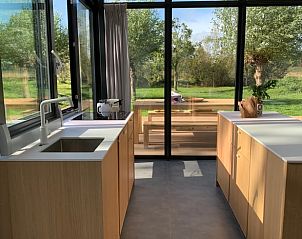 Modern kitchen in cottage in Kamperland overlooking terrace and nature in North Beveland, Zeeland.