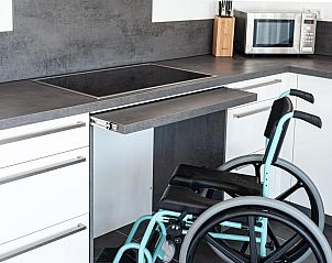 Stijlvolle slaapkamer in Duinvallei 22, vakantiehuis in Kamperland, Noord-Beveland, met kunst aan de muur en veel ruimte.