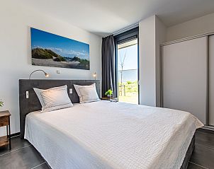 Lichte eetkamer in Duinvallei 22, vakantiehuis in Kamperland, Noord-Beveland, met grote ramen en uitzicht op de natuur.