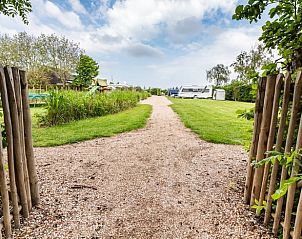 Natuurlijke toegangspoort naar Vakantiehuis in Scharendijke, omringd door groen in Schouwen-Duiveland, Zeeland.