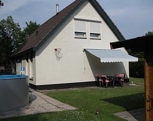 Achtertuin van vakantiehuis Mi Casa in Burgh-Haamstede met terras en zwembad, perfect voor zomerse dagen.