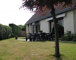 Zonnig terras van Mi Casa, Burgh-Haamstede, Zeeland, met zitgelegenheid voor buitenmaaltijden en ontspanning.
