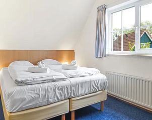 Lichte slaapkamer met groot raam in Villapark Livingstone 6-persoons villa in Burgh-Haamstede.