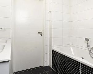 Stijlvolle badkamer met ligbad in Villapark Livingstone 6-persoons vakantiehuis in Schouwen-Duiveland.