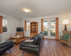 Gezellige woonkamer van Buitenhuis met sauna 6, vakantiehuis in Bruinisse, Schouwen-Duiveland, met comfortabele zithoek en uitzicht op de tuin.