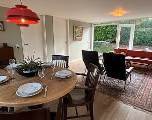 Gezellige binnenruimte van Vakantiewoning Het Ongerepte 21 'Kaatje Mossel' in Renesse, Zeeland, met eetgedeelte en uitzicht op de tuin.