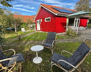 Vakantiewoning Het Ongerepte 21 'Kaatje Mossel' in Renesse, Zeeland, met zonnig terras en groene tuin voor een ontspannen verblijf.