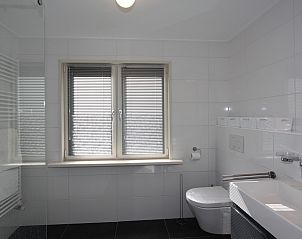 Helles Schlafzimmer mit roten Akzenten im Ferienhaus Duinweg 12 in Renesse, Zeeland.