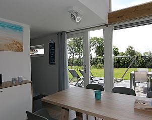 Eetruimte in Vakantiehuis Zonnedorp 7, De Meerpaal, Renesse met uitzicht op groene tuin.