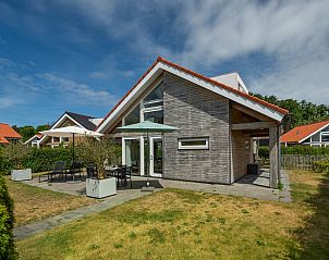 Gemtlicher Auenbereich des Ferienhauses Zonnedorp 8, De Zeehond in Renesse, Zeeland mit Sonnenschirmen.