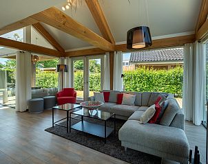 Helles Wohnzimmer des Ferienhauses Zonnedorp 8, De Zeehond in Renesse, Zeeland mit groen Fenstern.