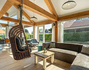 Lichte woonkamer met hangstoel in Vakantiehuis Zonnedorp 1, Solskin in Renesse, Schouwen-Duiveland.