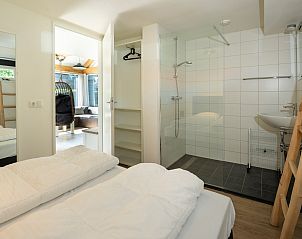 Slaapkamer met ensuite badkamer in Vakantiehuis Zonnedorp 1, Solskin in Renesse, ideaal voor privacy.