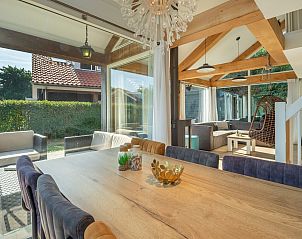 Ruime eetkamer met houten tafel in Vakantiehuis Zonnedorp 1, Solskin in Renesse, perfect voor familiediners.