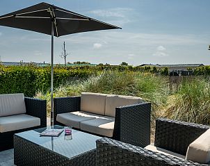 Genieen Sie die sonnige Terrasse des Ferienhauses Zonnedorp 15, Stuurboord in Renesse, Zeeland, umgeben von Natur und Ruhe.