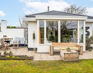 Ferienhaus Horizon by the Sea in Renesse, gemtliche Terrasse mit Holzmbeln und viel Grn.