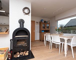 Das Esszimmer mit Kaminofen im Ferienhaus Horizon by the Sea, Renesse, bietet eine warme und gemtliche Atmosphre.