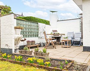 Gemtliche Terrasse mit Blumen und Gartenmbeln im Ferienhaus Horizon by the Sea, Renesse, perfekt fr das Leben im Freien.