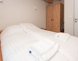 Schlafzimmer mit Holzschrank im Ferienhaus Horizon by the Sea, Renesse, bietet viel Stauraum.