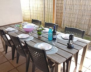 Gemtlicher Tisch im Freien auf der Terrasse des Ferienhauses Horizon 95 in Renesse, bereit fr eine Sommermahlzeit.