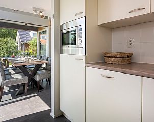 Kitchen overlooking dining room in Holiday home Zonnedorp 22 Anoes, Renesse.