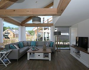 Modern living room of Holiday home Zonnedorp 18, Duinhuis 18 in Renesse, Zeeland with spacious sofa and TV.