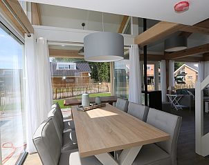Spacious dining room of Holiday Home Zonnedorp 18, Dune House 18 in Renesse, Zeeland overlooking the garden.