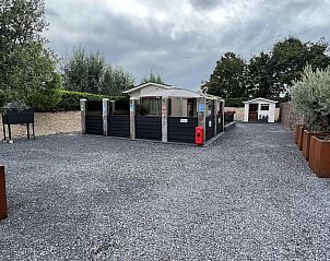 Ruime buitenruimte bij VZ2321 Vakantiechalet in Renesse, omgeven door groen in Zeeland.