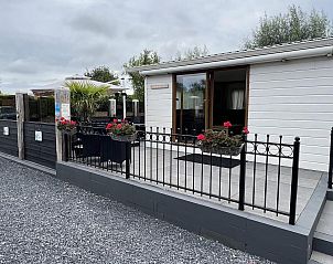 Entree en terras van VZ2321 Vakantiechalet in Renesse, Schouwen-Duiveland, met bloemen.