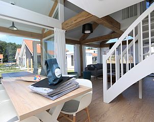 Dining area overlooking the garden at Het Witte Strandhuis in Renesse, Zeeland.