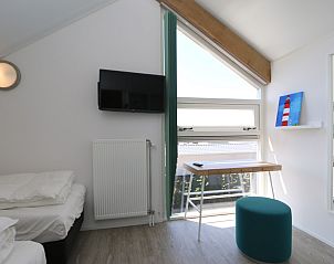 Attic room with workspace in Het Witte Strandhuis in Renesse, Zeeland.