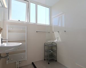 Bright bathroom with large windows in Het Witte Strandhuis in Renesse, Zeeland.