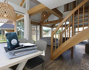 Grote ramen in de woonkamer van Vakantiehuis Zonnedorp 10 met uitzicht op de natuur.