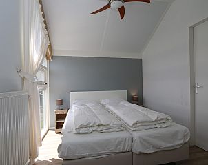 Grote eettafel in Vakantiehuis Zonnedorp 10 met uitzicht op de tuin in Zeeland.