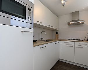 Moderne Essecke im Ferienhaus Zonnedorp 23, Zeeland House, Renesse, mit Holzdetails.