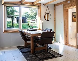 Dining room overlooking the garden in Huisje in Renesse, a vacation home in beautiful Zealand.