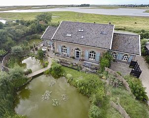 Luchtfoto van Lodge Tureluur, een vakantiehuis in Kerkwerve, omgeven door weelderige natuur en water.