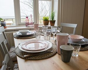 Gezellig gedekte eettafel in Lodge Tureluur, vakantiehuis in Zeeland met uitzicht op de natuur.