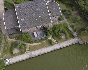 Luchtfoto van Lodge Tureluur in Kerkwerve, Zeeland, met groene tuinen en serene wateren.