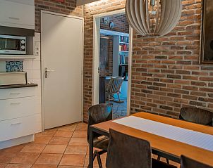 Eetkamer in Vakantiewoning Kamperfoelieweg 13, Nieuw-Haamstede met moderne eettafel en sfeervolle verlichting.