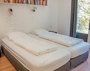 Ruime slaapkamer met boekenplank in Vakantiewoning Kamperfoelieweg 13, Nieuw-Haamstede.