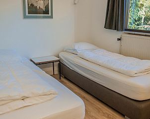 Slaapkamer met uitzicht op de tuin in Vakantiewoning Kamperfoelieweg 13, Nieuw-Haamstede, Zeeland.