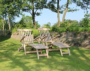 Comfortabele ligstoelen in de tuin van Vakantiehuis Duinhuis 11, Noordwelle, Schouwen-Duiveland, omgeven door natuur.