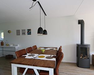 Eetgedeelte van Vakantiehuis Duinhuis 11 in Noordwelle, Schouwen-Duiveland, met een grote houten tafel en stijlvolle verlichting.