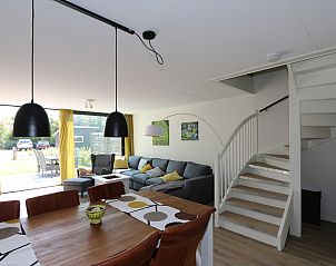 Ruime woonkamer van Vakantiehuis Duinhuis 11 in Noordwelle, Schouwen-Duiveland, met open trap naar bovenverdieping.